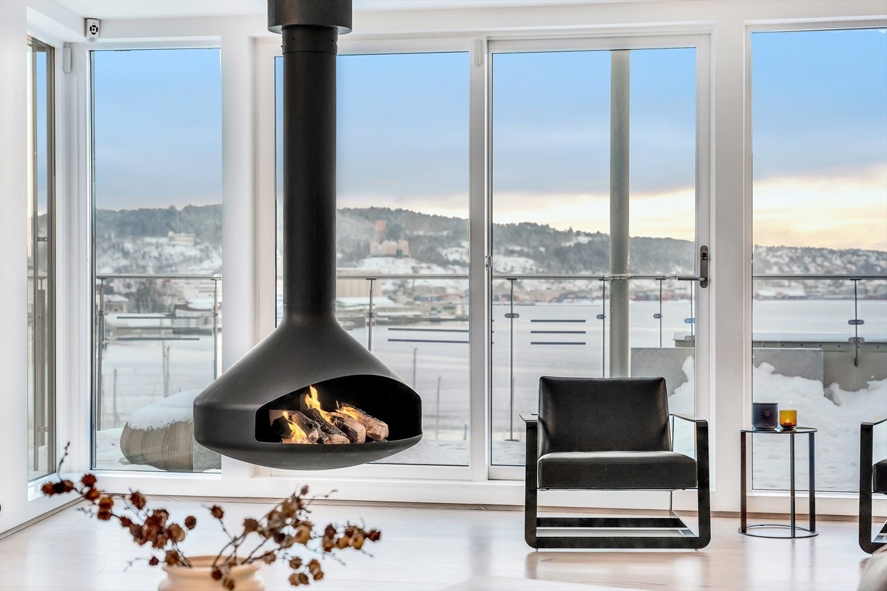 Stilig fritthengende peis i en stuen. Galleribilde