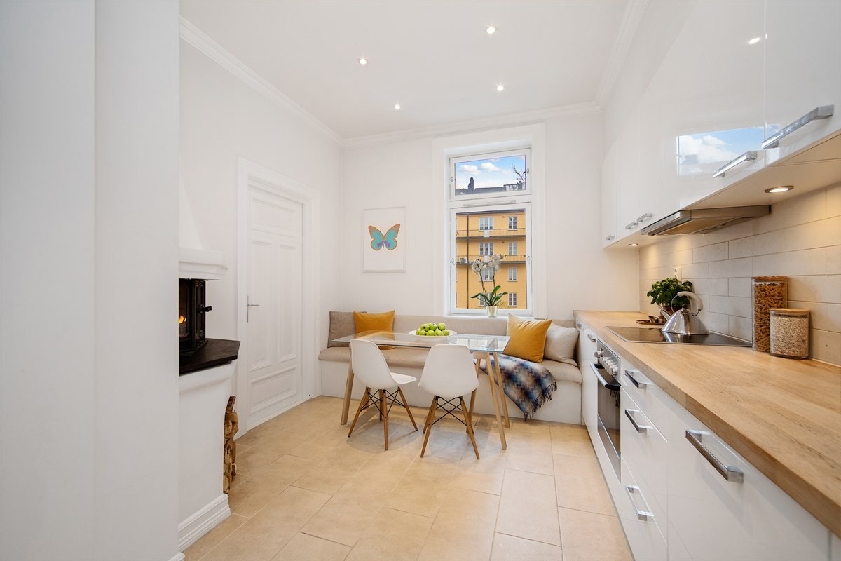 Kjøkkenet er moderne og stilfullt, samtidig som det er meget hyggelig med plassbygd sittebenk ved vindu og flott peisinnsats Galleribilde