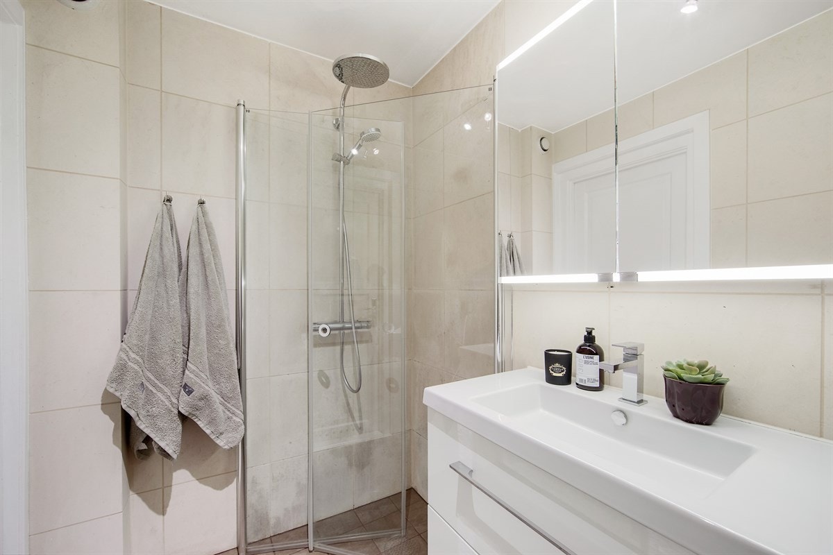 Det er dusjhjørne med praktiske, innfellbare glassdører og deilig regnfallsdusj Galleribilde