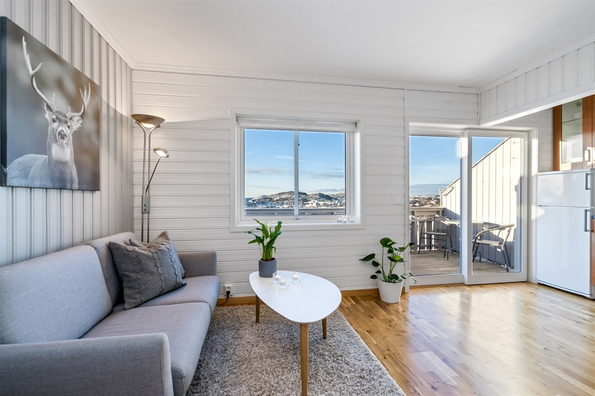 Rommet har store vindusflater og en skyvedør med utgang til en hyggelig balkong.