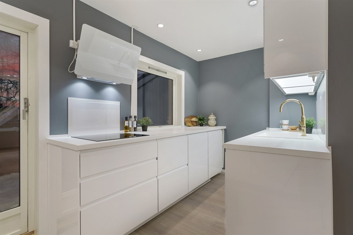 Kjøkkenet er malt i moderne gråtoner og har flere lekre detaljer som må sees Galleribilde