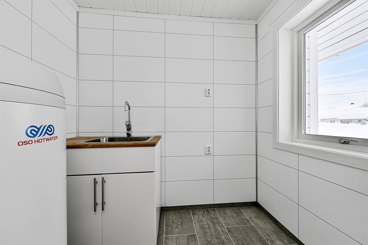 Vaskerommet ligger i tilknytning til entreen, noe som kan være kjærkomment for barnefamilier og dyrehold. Rommet har hvite flisplater og stilige gulvfliser i naturtro utførelse. Galleribilde