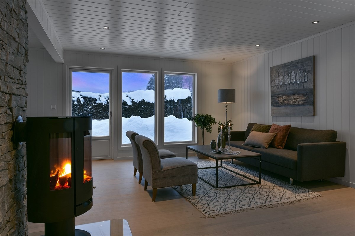 En glassdør og vindusflater på tre sider fyller rommet med naturlig lys, og downlights sørger for stemningsfull kveldsbelysning. Galleribilde