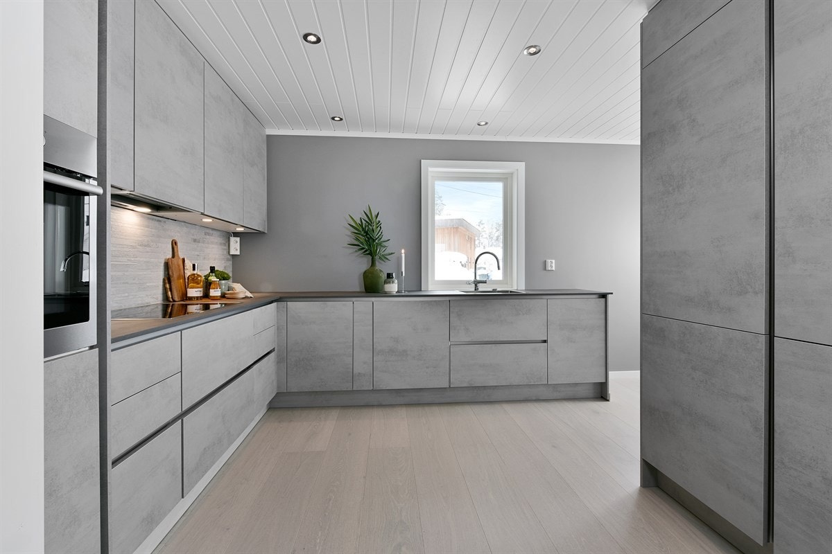 Kjøkkenet har et tidsriktig og praktisk design med takhøye overskap og gode arbeidsbenker. Galleribilde