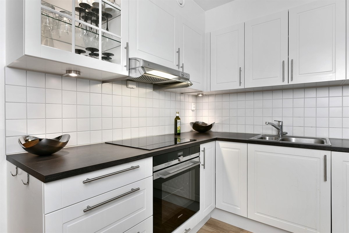 Kjøkkenet har integrerte hvitevarer som består av platetopp, stekeovn og oppvaskmaskin. Over kokesonen er det ventilator tilknyttet boligens ventilasjonssystem og det er montert komfyrvakt. Galleribilde