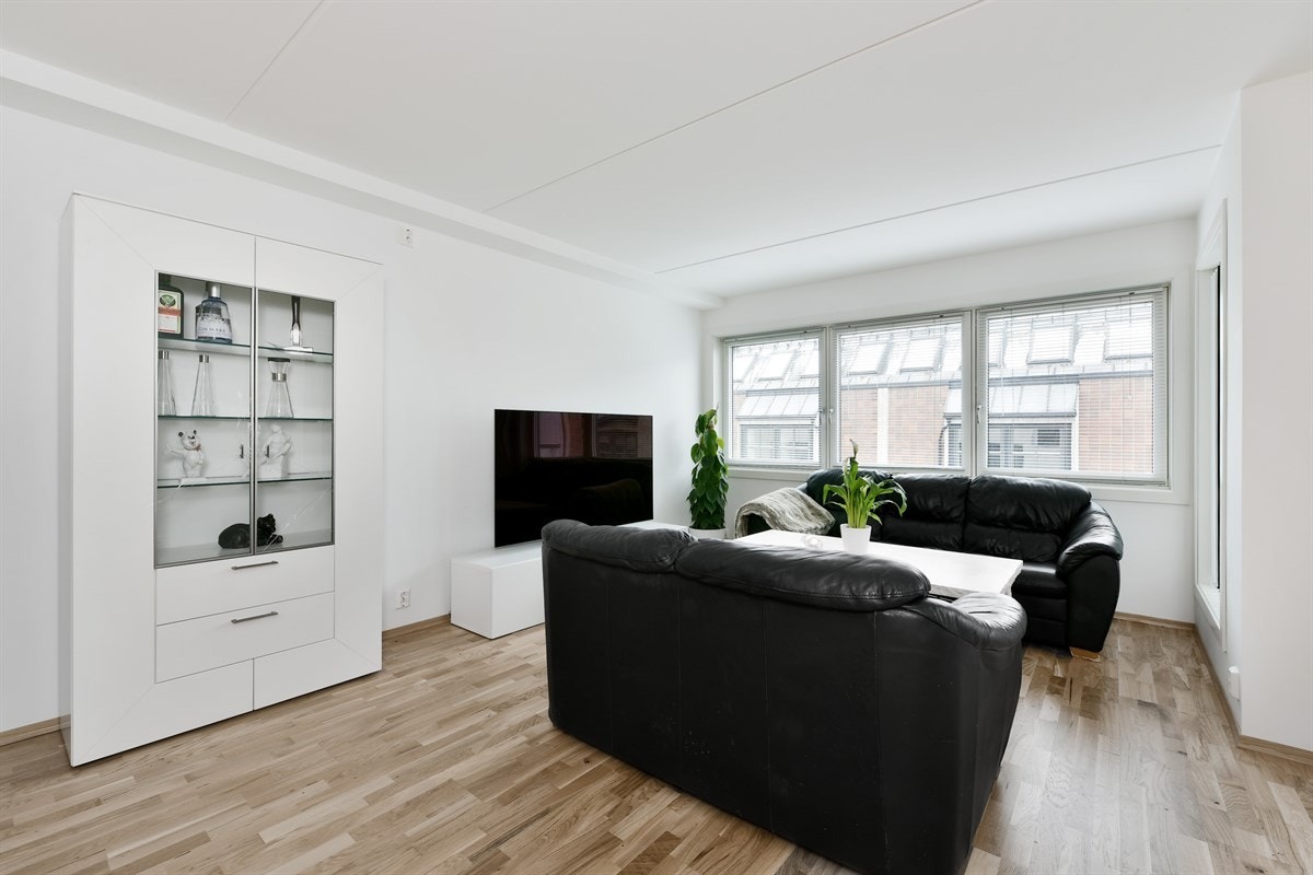 Leiligheten har en lys stue med gode vindusflater, hvite vegger og parkettgulv, som er gjennomgående for alle oppholdsrom. Galleribilde