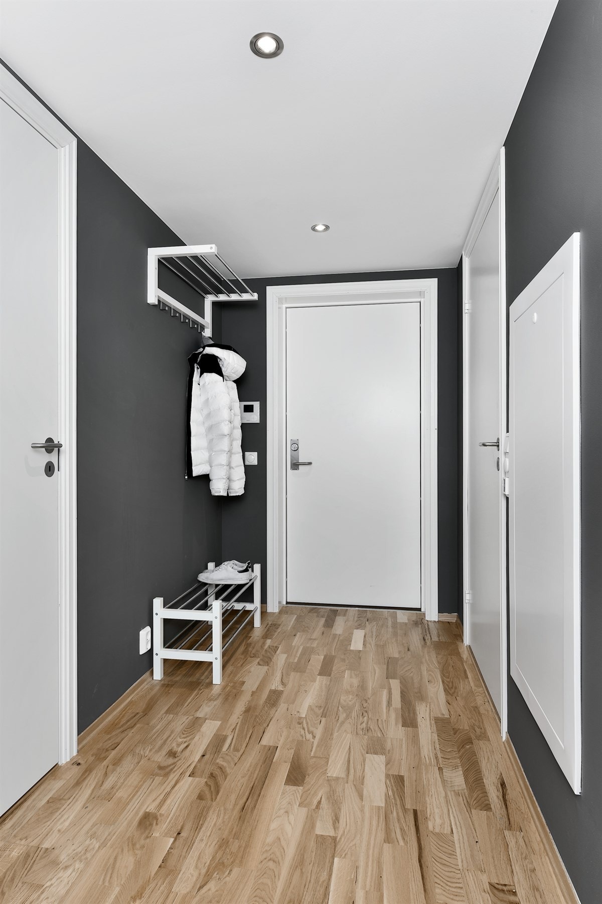 Entreen har hattehylle med knagger for enkelt oppheng, og det er åpen løsning til stue og kjøkken. Galleribilde