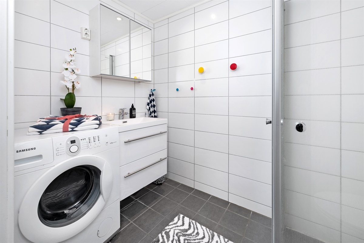 Boligen har et nyere bad fra 2015 med gulvvarme og downlights. Badet er pent fliset med hvite fliser på veggene og grå fliser på gulv. Galleribilde