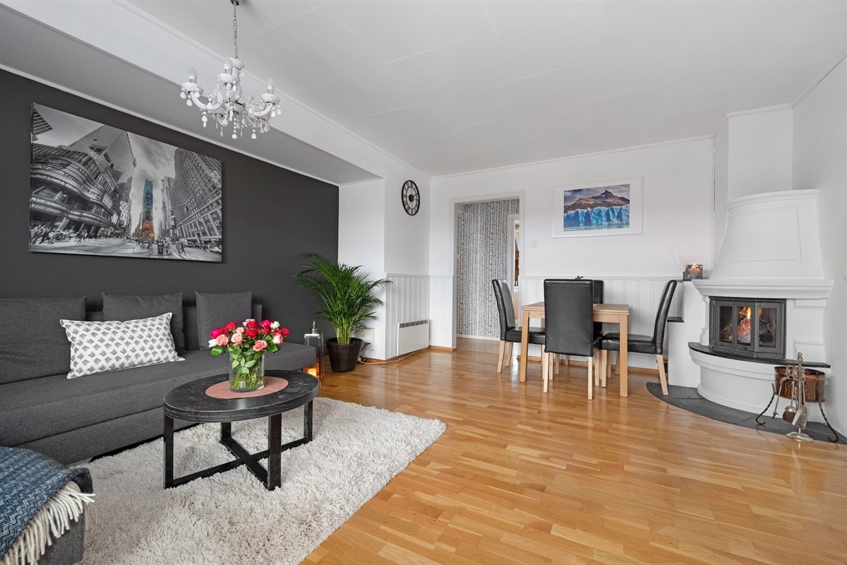 Leiligheten har en koselig og innbydende stue holdt i tidsriktige farger. Stuen har parkettgulv, lysmalt brystningspanel og vegger, samt en mørkegrå kontrastvegg. Galleribilde