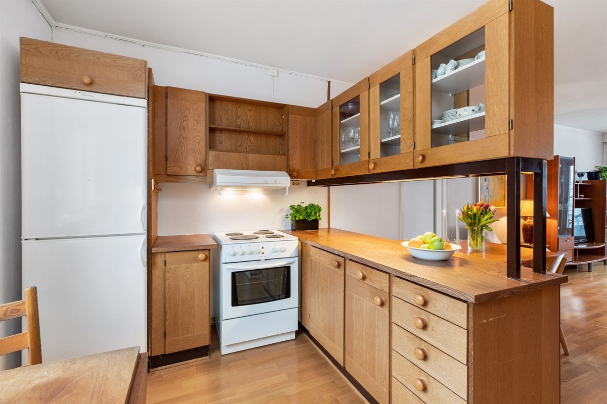 Eldre, men velholdt kjøkken med eik og vitrine fronter Galleribilde