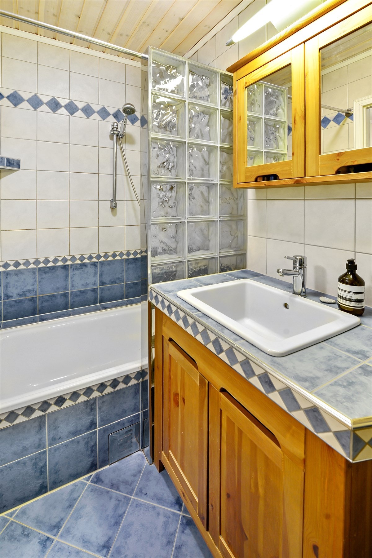 Flislagt bad med lun gulvvarme. Badet er utstyrt med et frittstående toalett, servantinnredning samt et innmurt badekar. Galleribilde