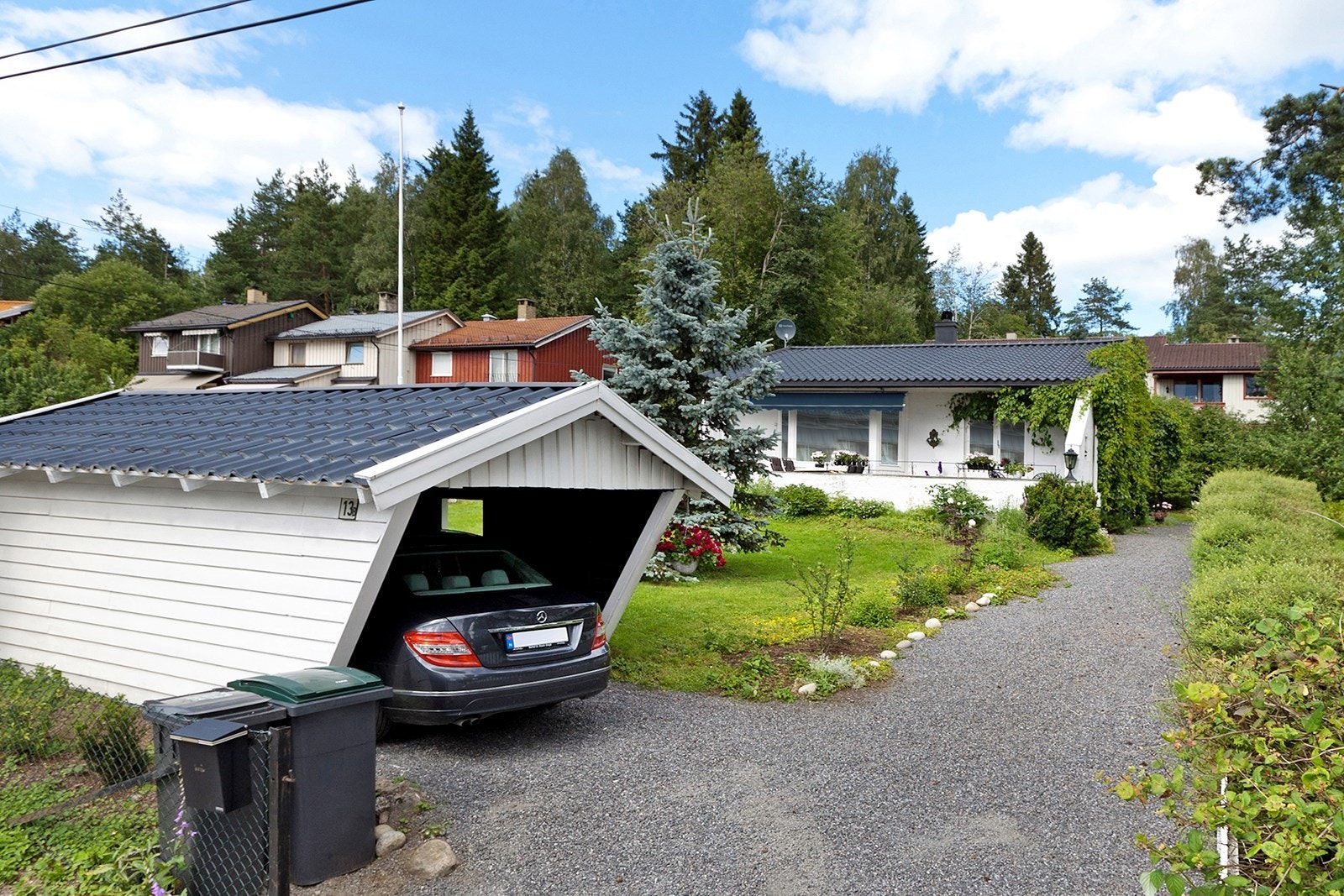 Fra carporten er det koselig gruslagt gangsti opp til boligen. Sommerbilder fra ca. 2011. Galleribilde