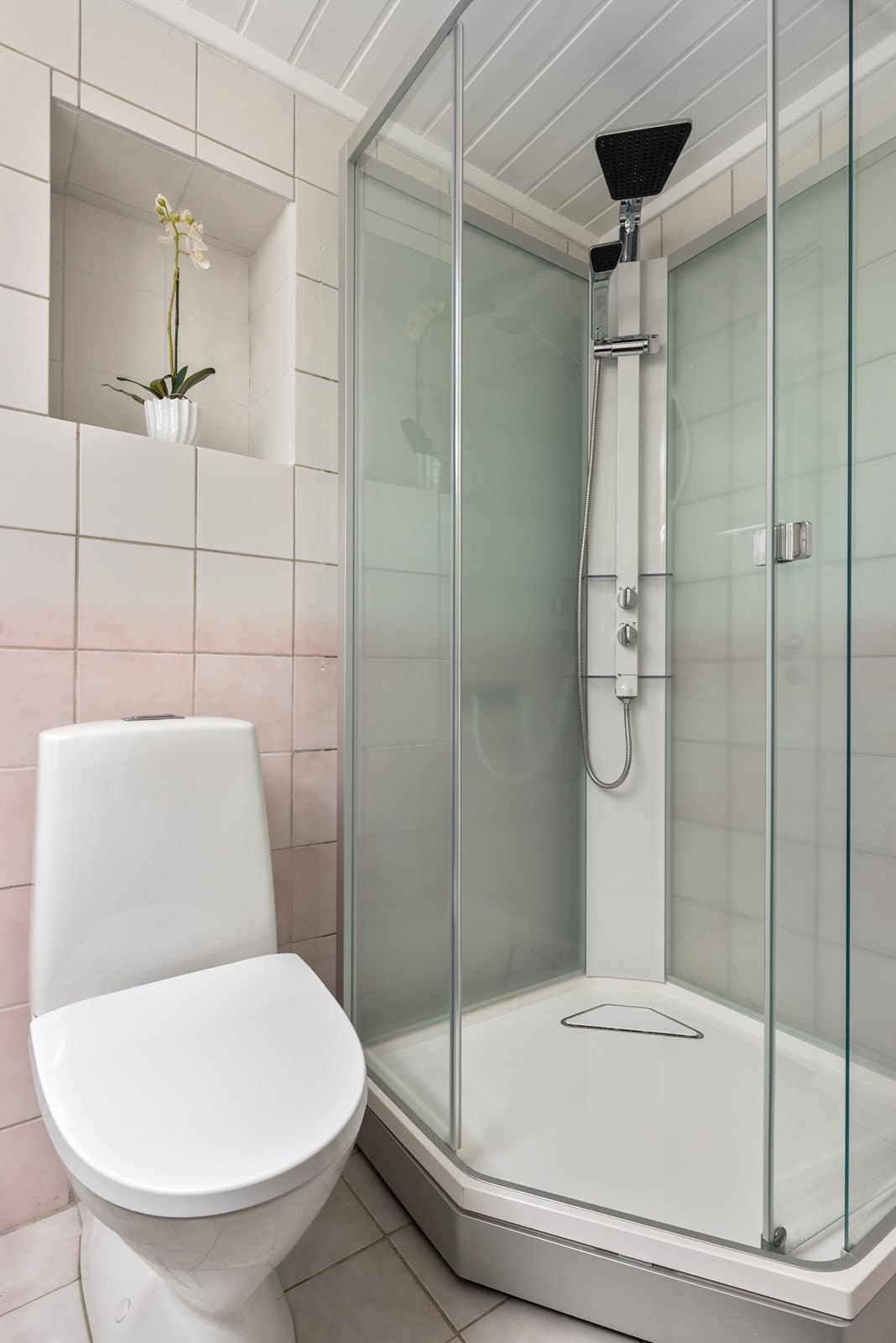Badet har blant annet varmekabler på gulv, en stor servant med god oppbevaringsplass, toalett og dusjkabinett. Galleribilde