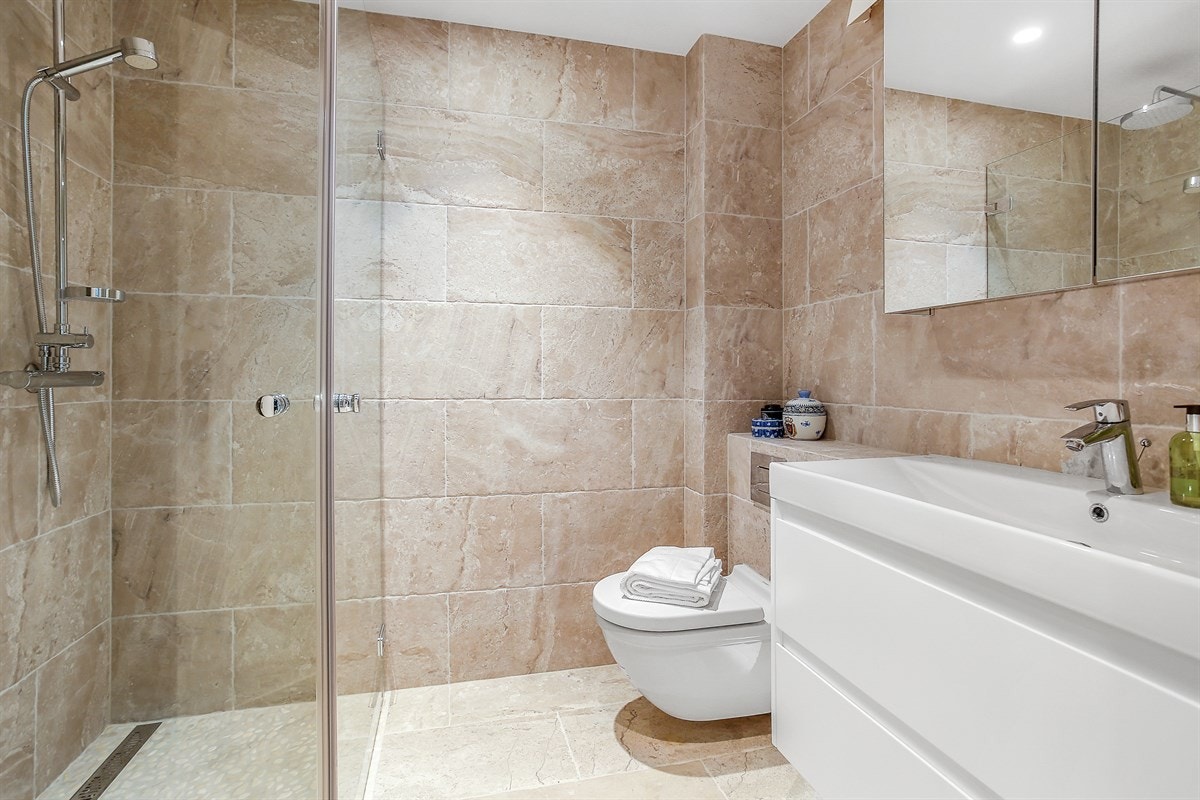 Badet tilknyttet gangen er utstyrt med gulvvarme, downlights, veggmontert toalett, samt både håndholdt- og behagelig regnfallsdusj. Galleribilde