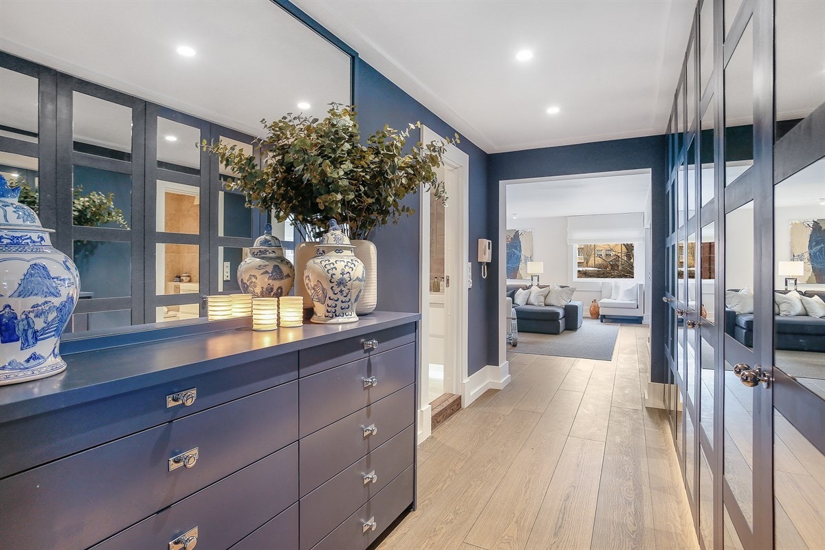 Plassbygd skapinnredning i gang/entré. Skapene har fronter med speil og rammer og fyller omtrent hele den ene langveggen. Galleribilde