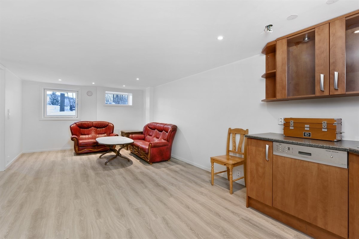 I underetasjen har eneboligen en lys og tiltalende stue med åpen løsning mot kjøkken. Galleribilde