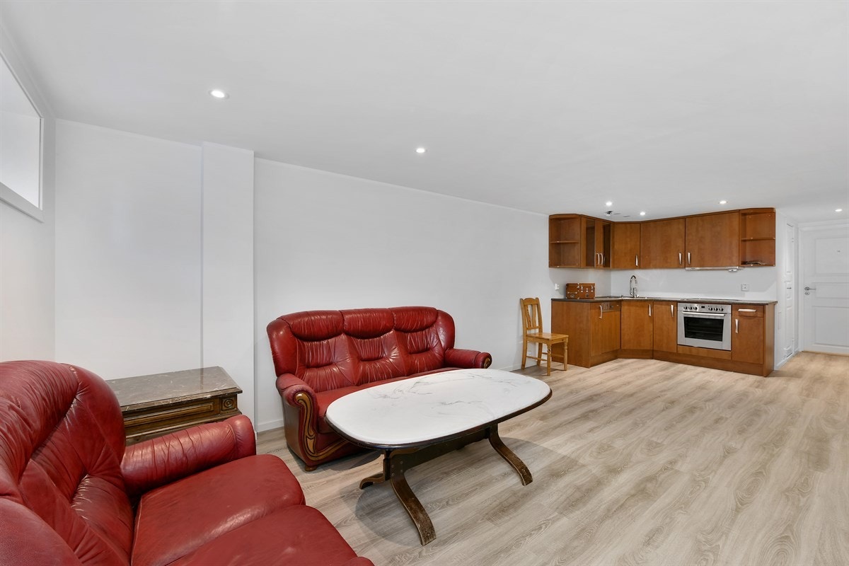 Kjøkkendelen har innredning i L-form i hjørnet av rommet. Galleribilde