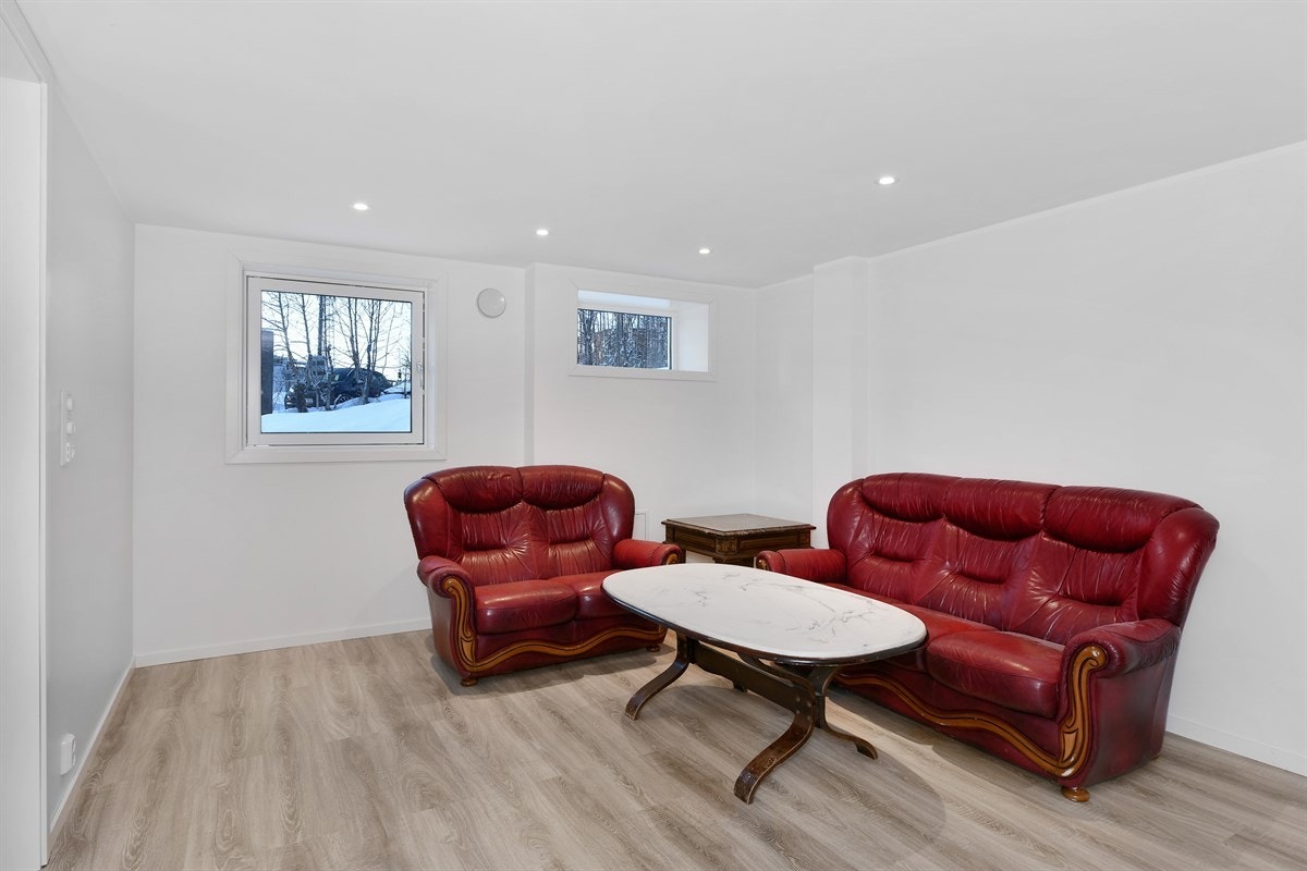 Stuen har laminat på gulv, hvitmalte vegger, og downlights. Galleribilde