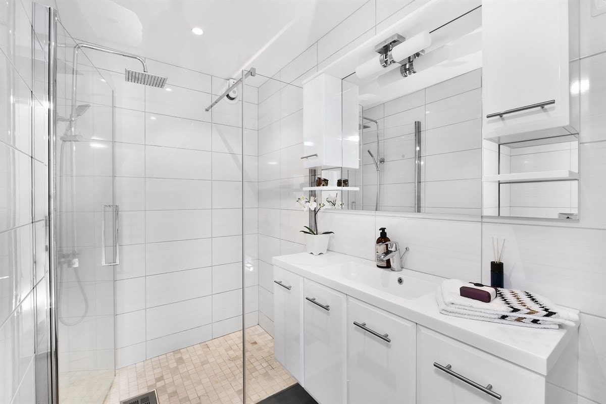 Badet i første etasje har mørke gulvfliser, lyse veggfliser, downlights, gulvvarme og fuktstyrt vifte. Galleribilde