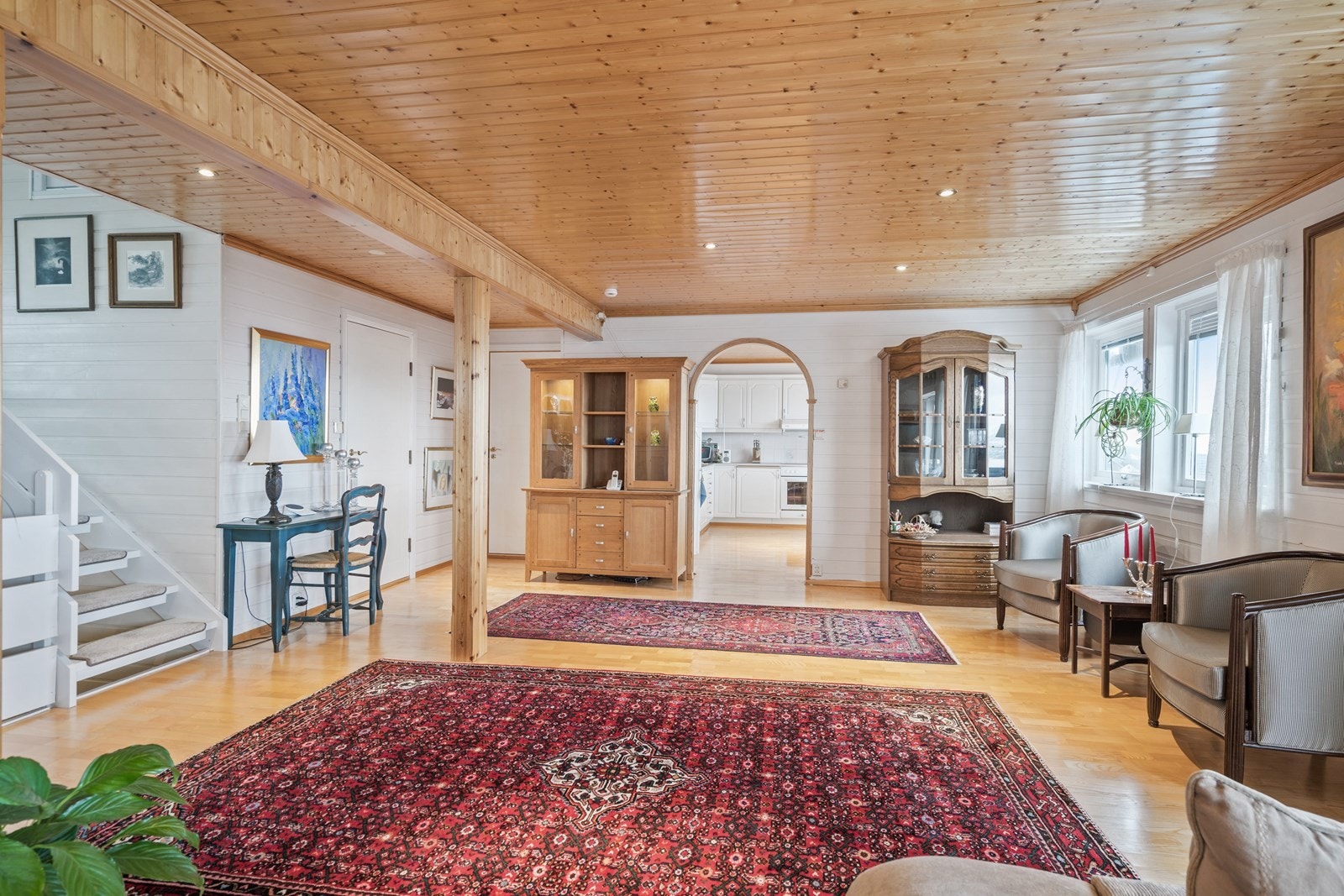 Stuen har parkettgulv, lyse panelvegger og downlights i taket Galleribilde