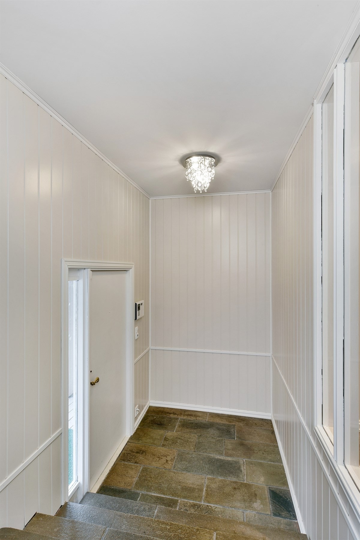 Entreen går over to nivåer som er adskilt av flislagt trapp. Galleribilde