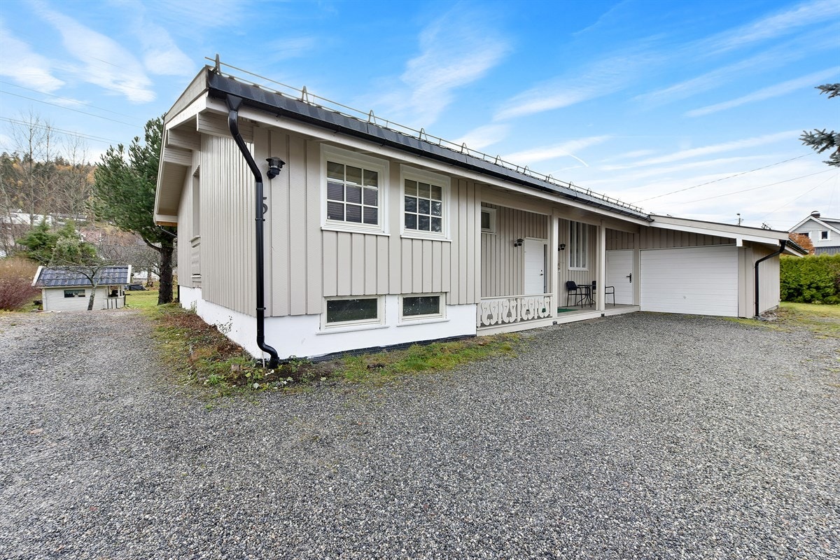 Det er parkering i tilbygget enkelgarasje med innlagt strøm og lys. Her er det også en sportsbod/innredet rom og lagringsloft. Biloppstillingsplass på tomten. Galleribilde