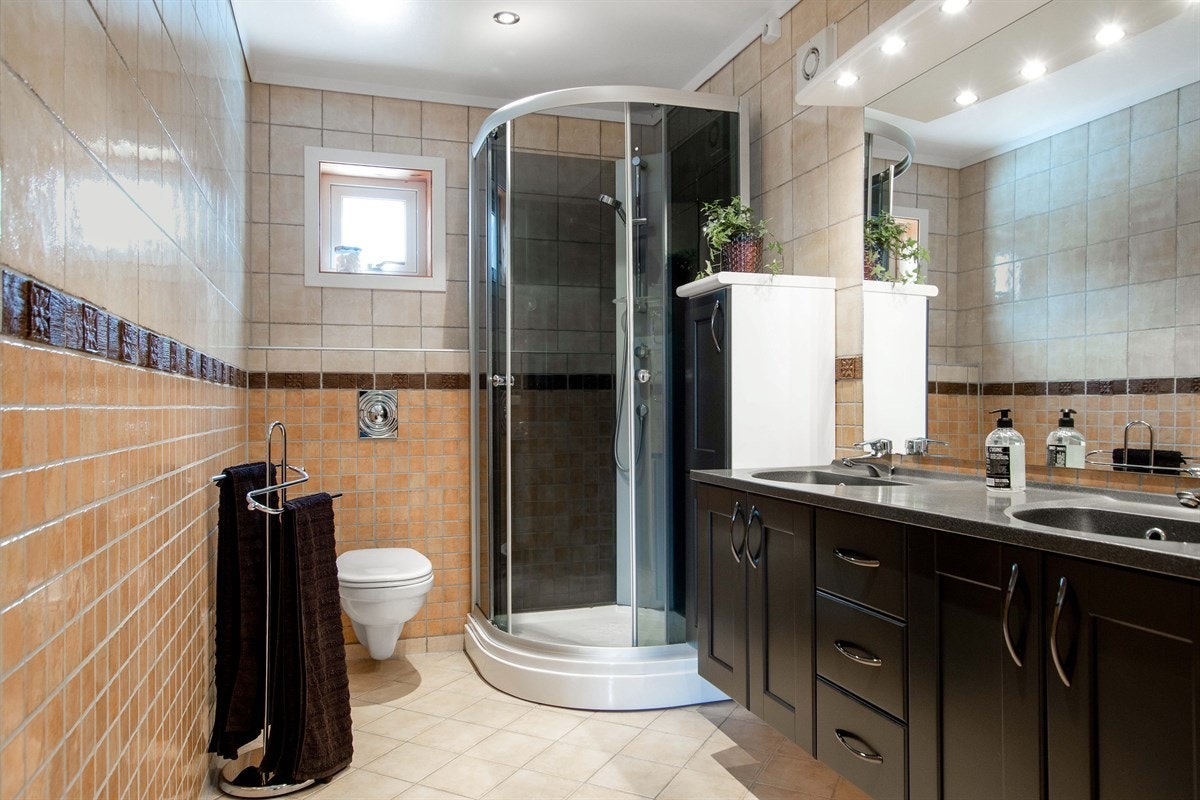 Badet i andre etasje ligger i tilknytning til hovedsoverommet. Badet er fornyet i 2019 og har lyse fliser på gulv og vegger. Galleribilde