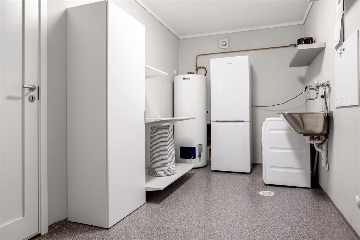 Vaskerommet i første etasje har opplegg for vaskemaskin og tørketrommel, samt nytt høyskap og hyller fra 2019. Galleribilde