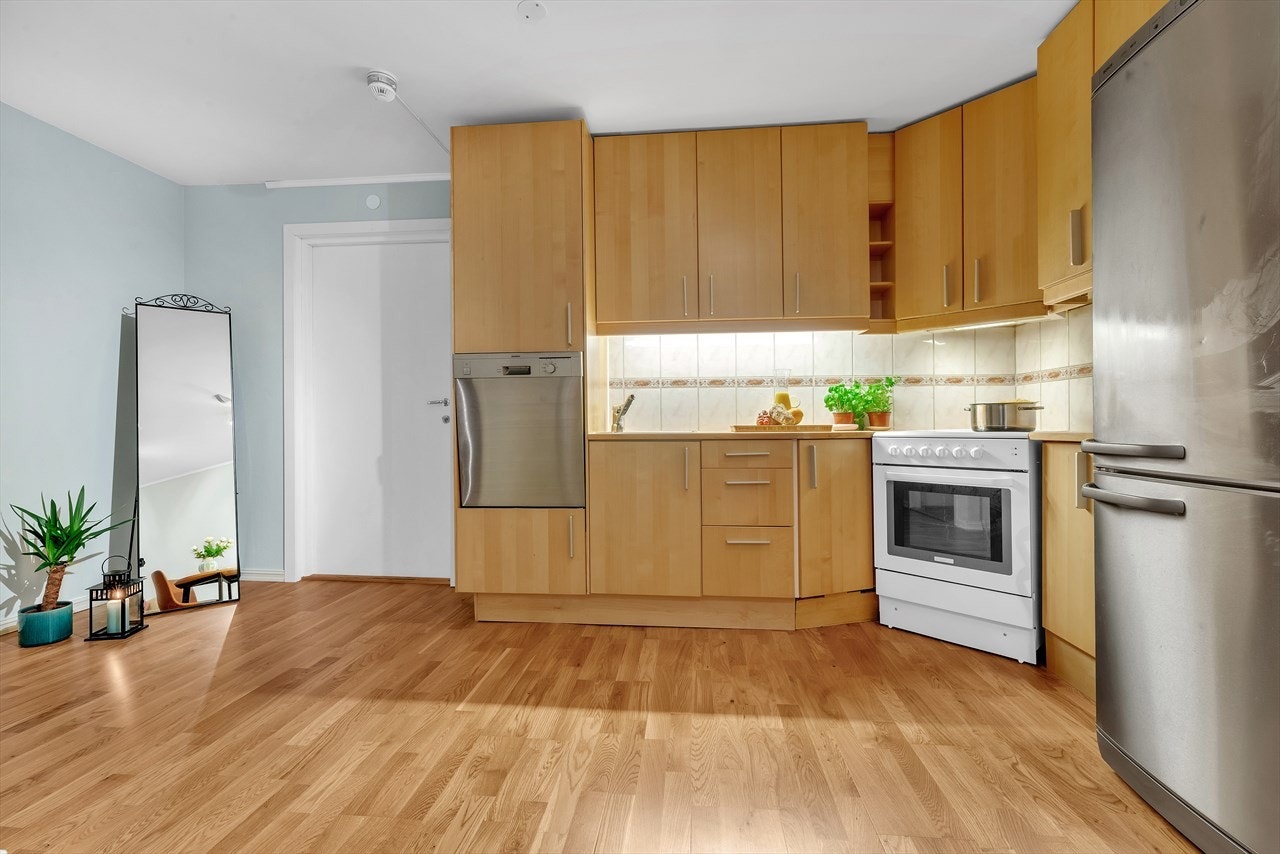 Med sin åpne løsning mot entré og stue er kjøkkenet både plassbesparende og praktisk. Galleribilde