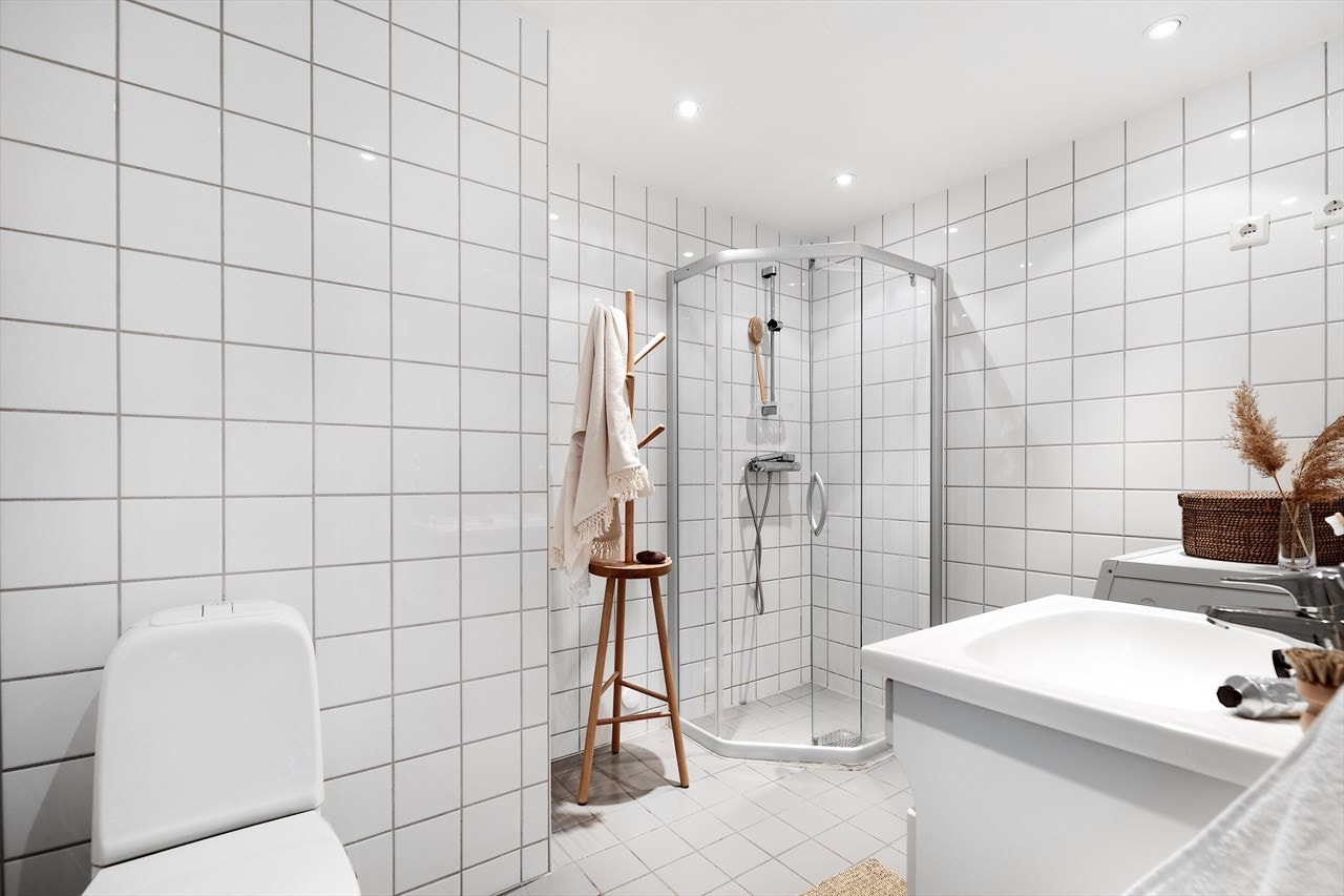 Lyst flislagt bad med gulvvarme og downlights i taket. Galleribilde