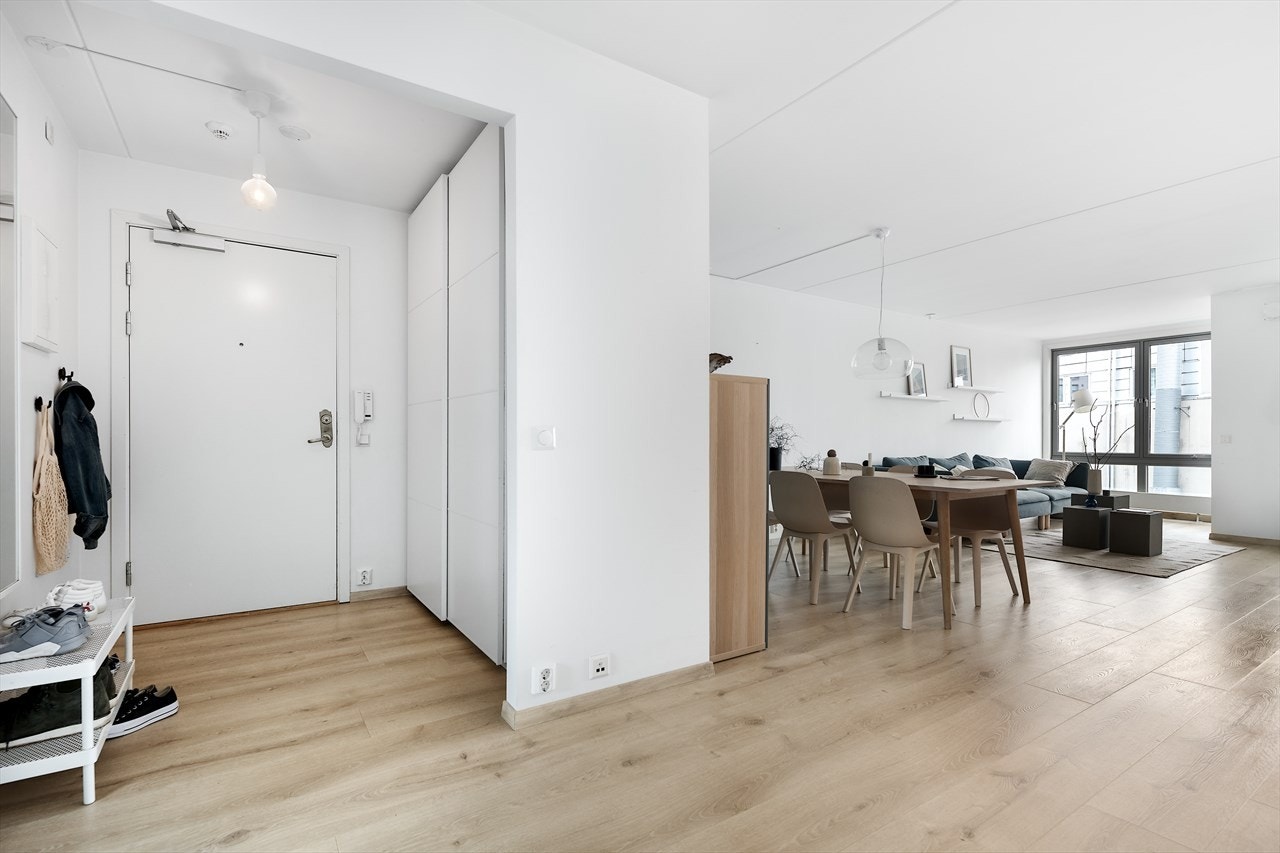 Luftig gang med skyvedørsgarderobe og porttelefon på veggen. Galleribilde