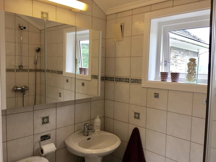 Praktisk bad med dusj, vask, toalett og vaskemaskin. Galleribilde