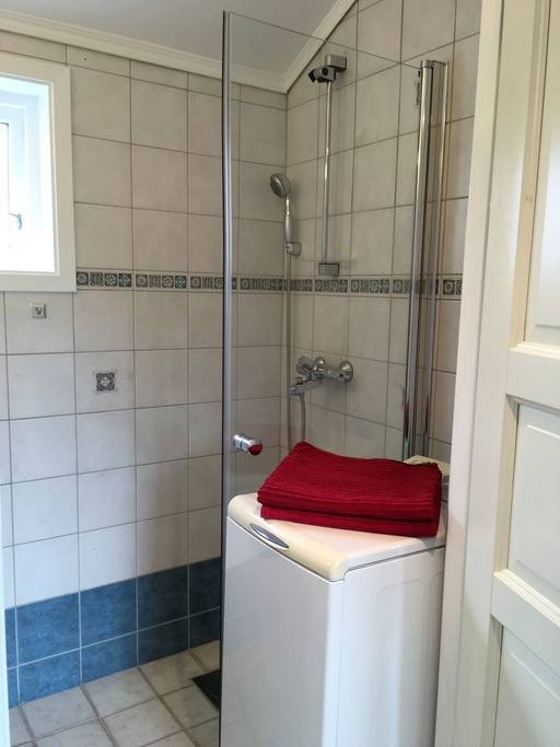 Praktisk bad med dusj, vask, toalett og vaskemaskin. Galleribilde