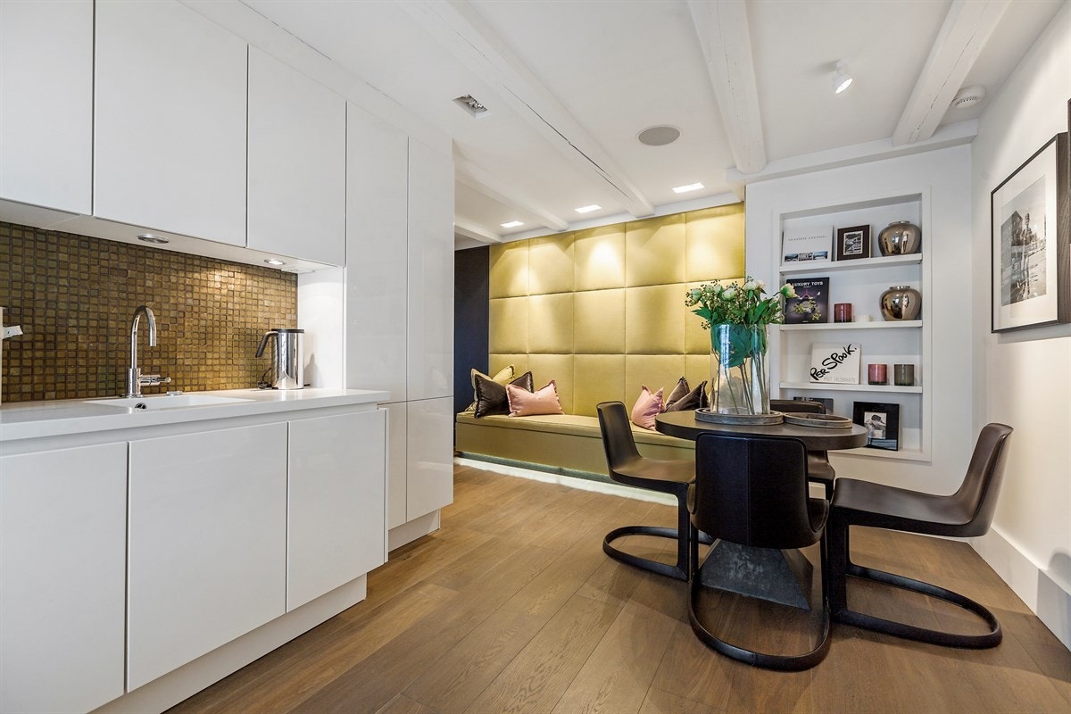 Det andre kjøkkenet ligger i vestre fløy og har takhøy innredning med hvite høyglansfronter og integrerte grep. Galleribilde