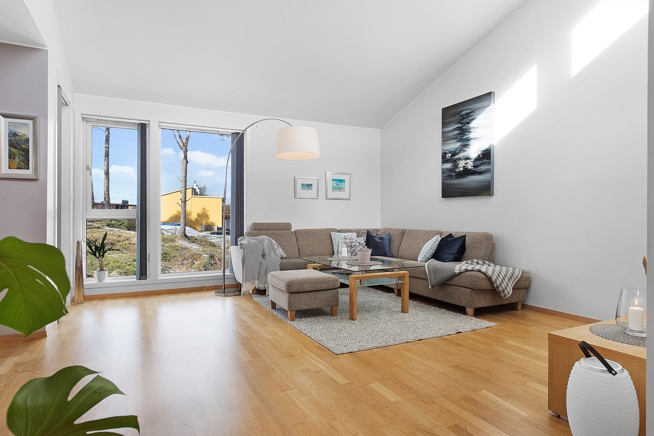 Stor og romslig stue med mange innredningsmuligheter. Det er parkett på gulv og malte lyse vegger. Galleribilde