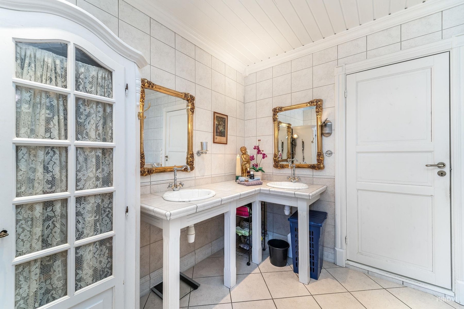 Det er plassbygget innredning med to servanter og flis på benk. Galleribilde