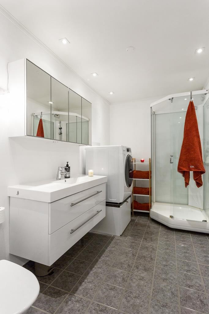 Lekkert flislagt bad med varmekabler og opplegg for vaskemaskin Galleribilde