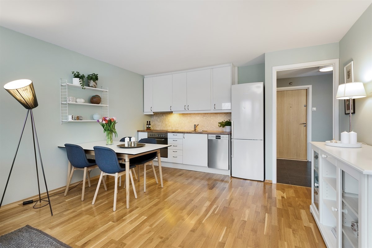 Lyst kjøkken som er innredet med glatte fronter og benkeplate i laminat. Nedsenket kum i rustfritt stål Galleribilde