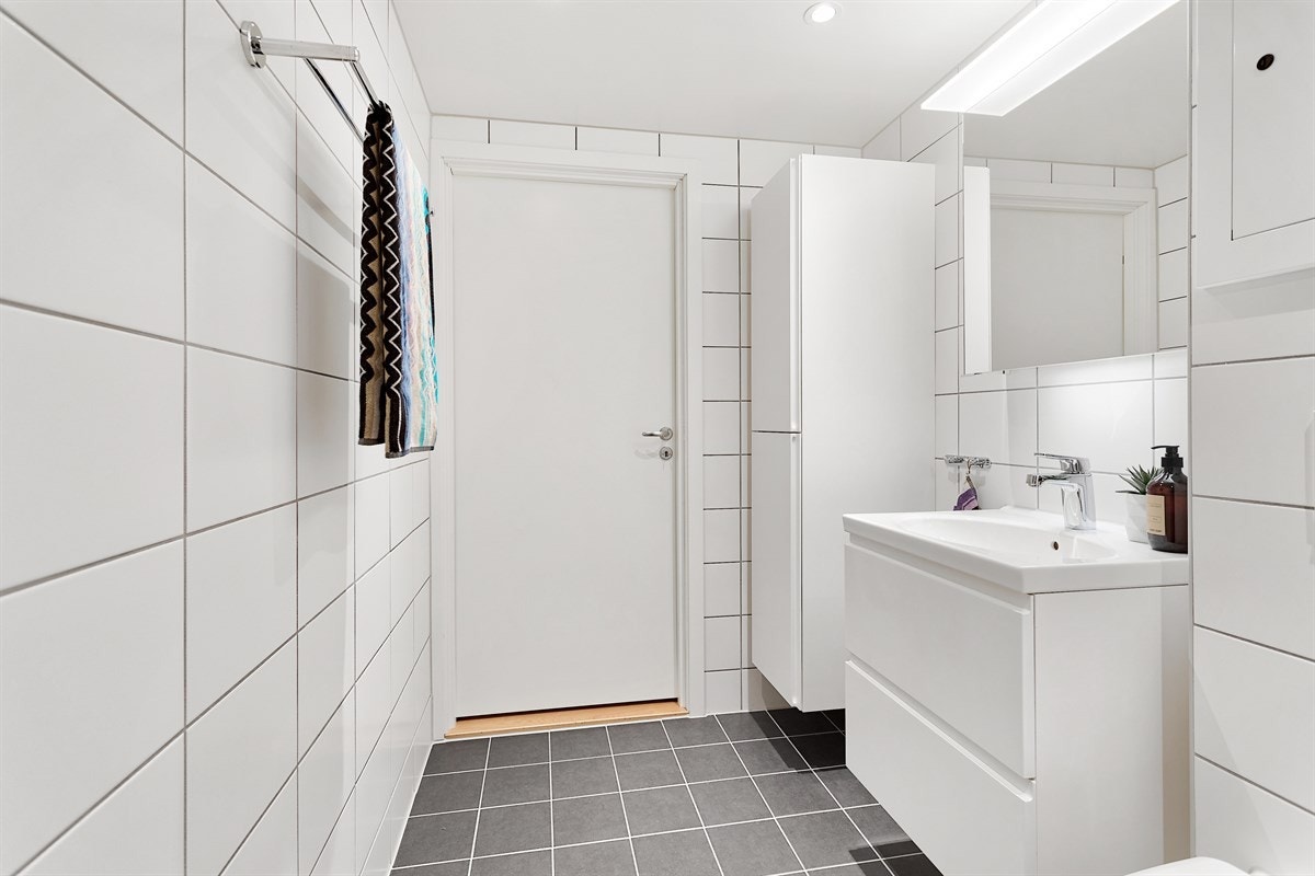 Det er downlights og opplegg til vaskemaskin. Flislagt gulv med gulvvarme i baderom Galleribilde