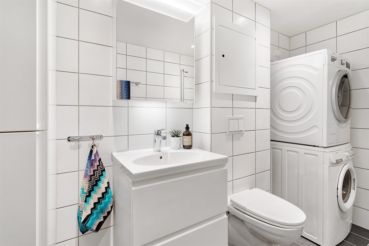 Baderommet inneholder veggmontert klosett/wc, servant, speil, belysning og dusjhjørne. Dusj rett på gulv. Skjult røropplegg samt Utpåliggende røropplegg med kromrør. Sluk i plast/pvc, klemring. Ventilasjon med veggventil og luftespalte under badedør Galleribilde