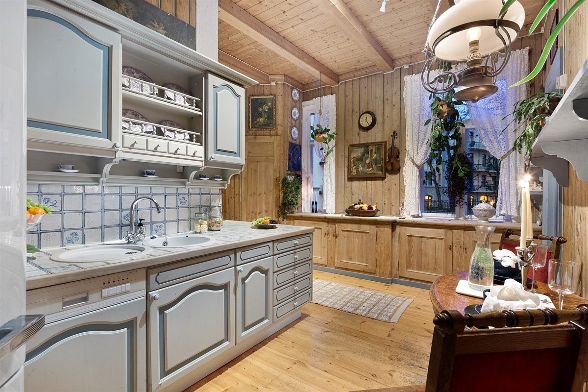 Kjøkkenet er lunt og trivelig med åpen peis og plass til spisebord Galleribilde