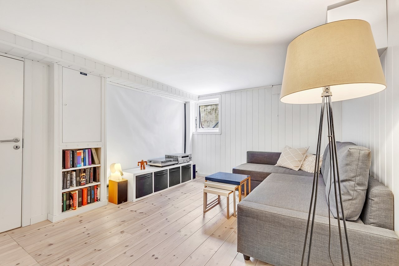 Kjellerstue med vindu og tregulv. Perfekt til bruk for små tv-tittere. Innredet som stue (ikke omsøkt til rom for varig opphold). Galleribilde