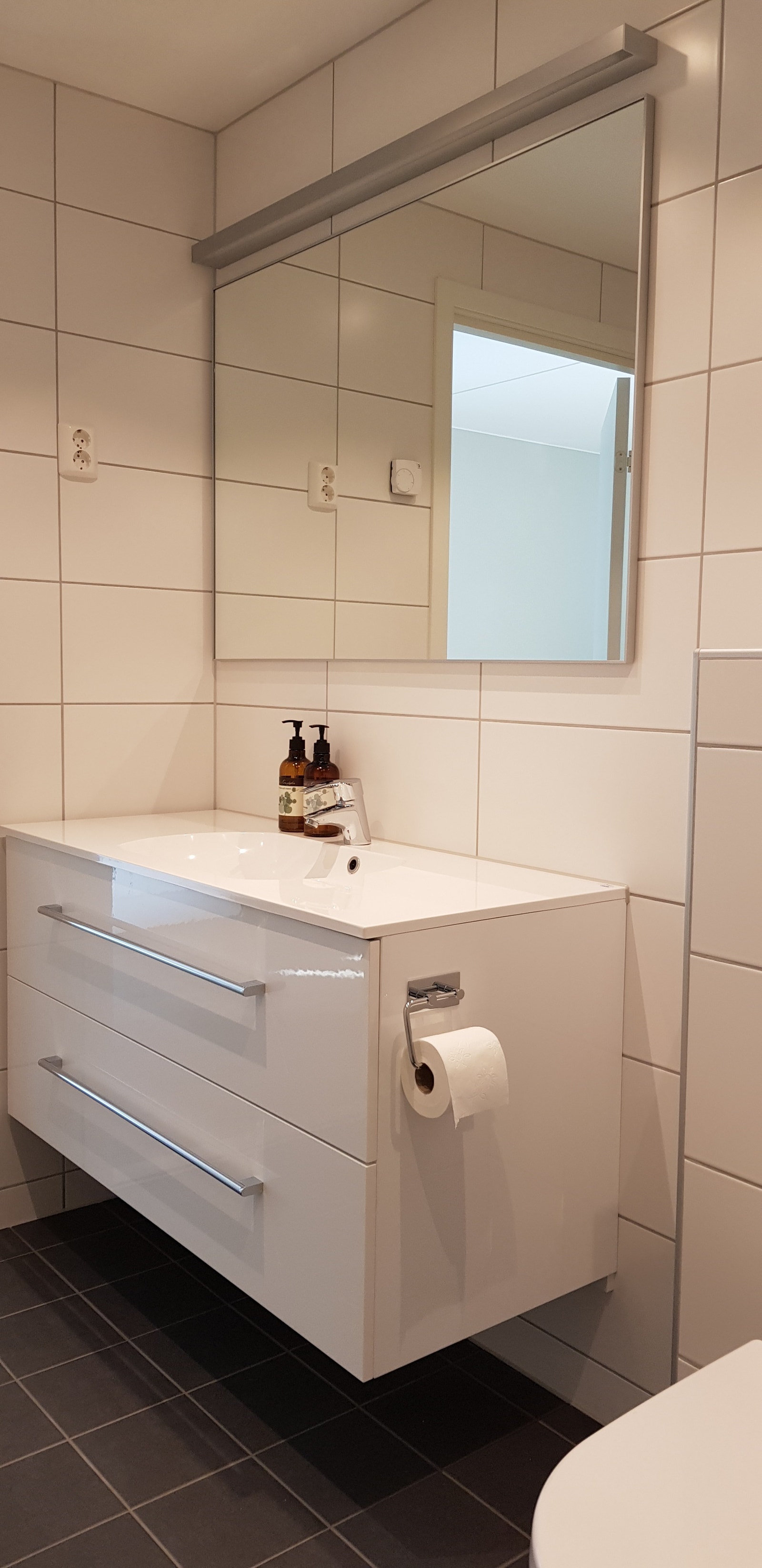 Baderomsbenken inneholder store og romslige skuffer. Speilet over vasken har god belysning. Galleribilde