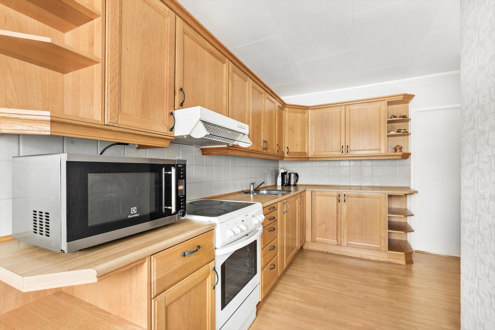 Stort og lyst kjøkken med rikelig skap- og benkplass. Galleribilde