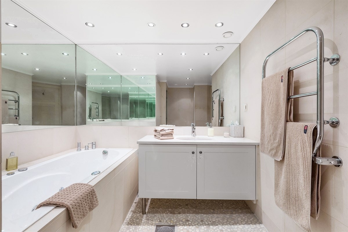 Delikat bad med kalksteinfliser av typen Caliza Capri og servantskap fra Bache- Wiig & Reitan med en tykk Caliza Capri benkeplate. Galleribilde