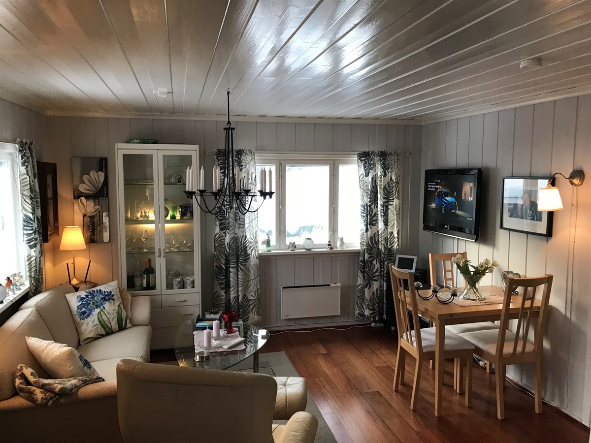 Lys og pen stue med parkett på gulv og lysmalt panel på vegger og tak Galleribilde