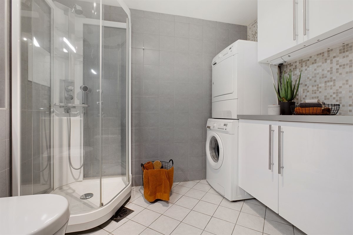 Bad I er innredet med dusjkabinett, og har opplegg for vaskemaskin og tørketrommel. Galleribilde