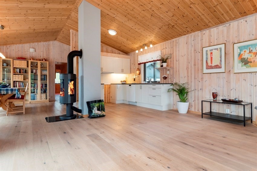 Åpen stue-kjøkken løsning med peisovn i midten av rommet. Galleribilde