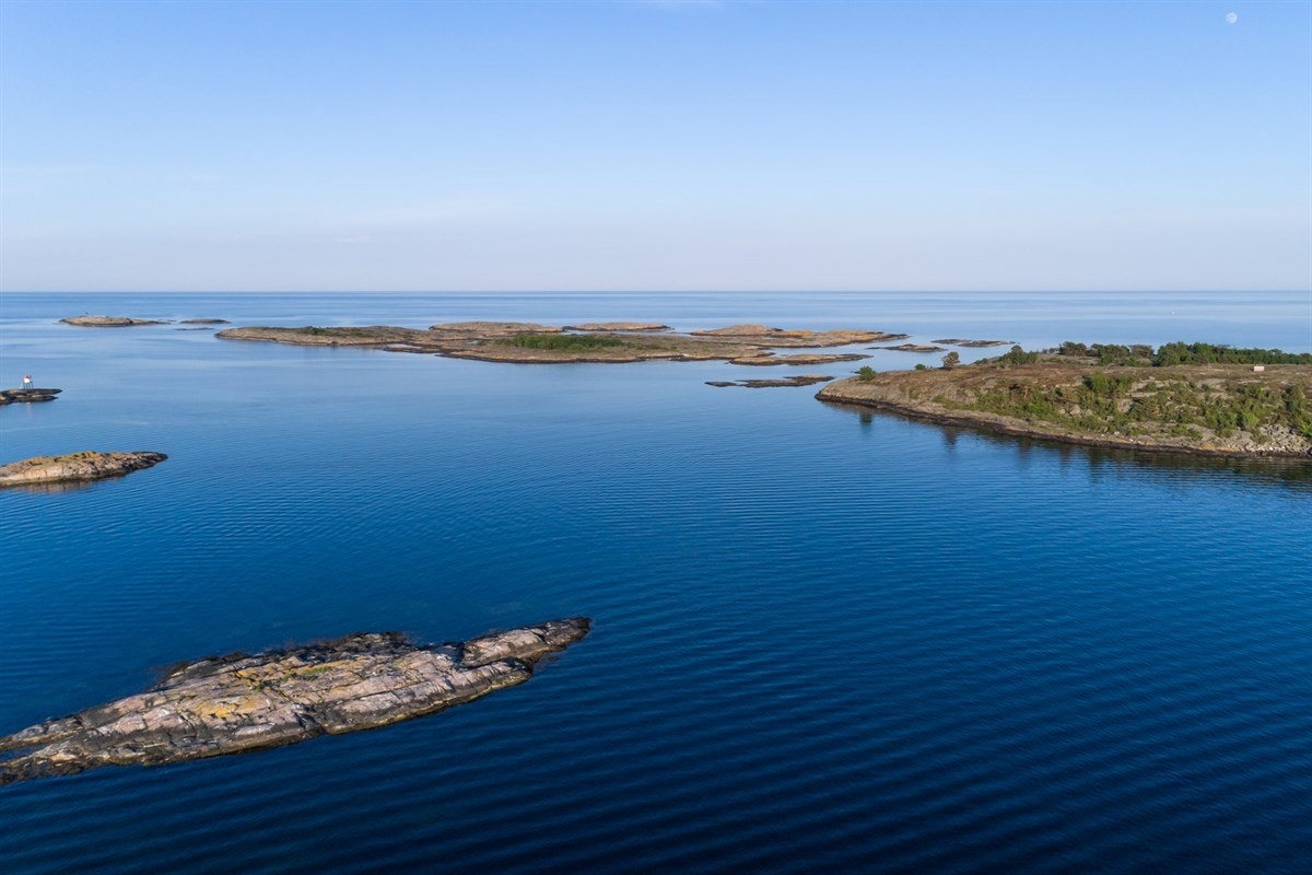 Flatskjæra med mange fine badeplasser, lune viker, strandlaguner og flotte blankskurte svaberg Galleribilde