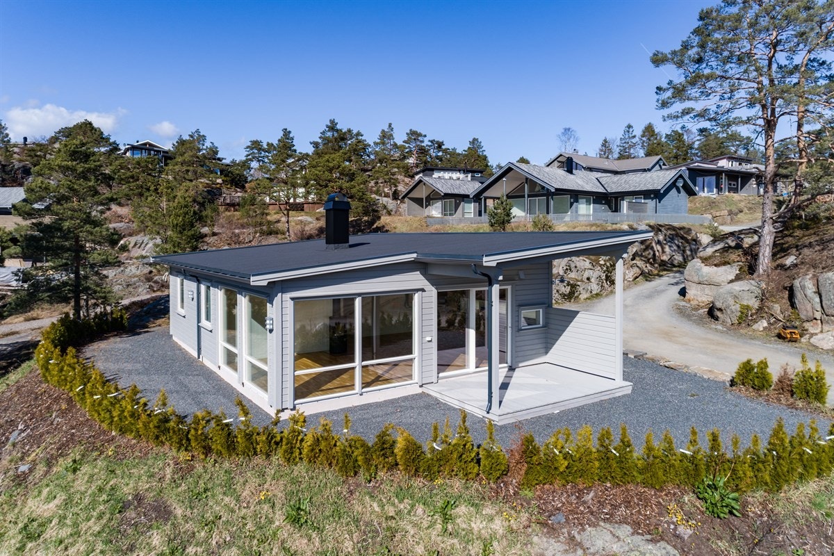 Opparbeidet tomt med terrasse, gruset tun og hekk rundt eiendommen Galleribilde